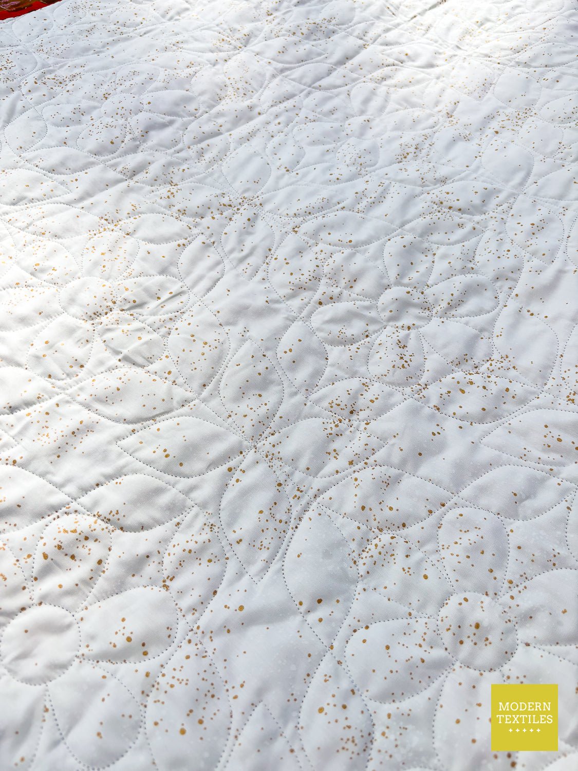 All-over Daisy Peel quilting creating soft floral texture on the quilt.