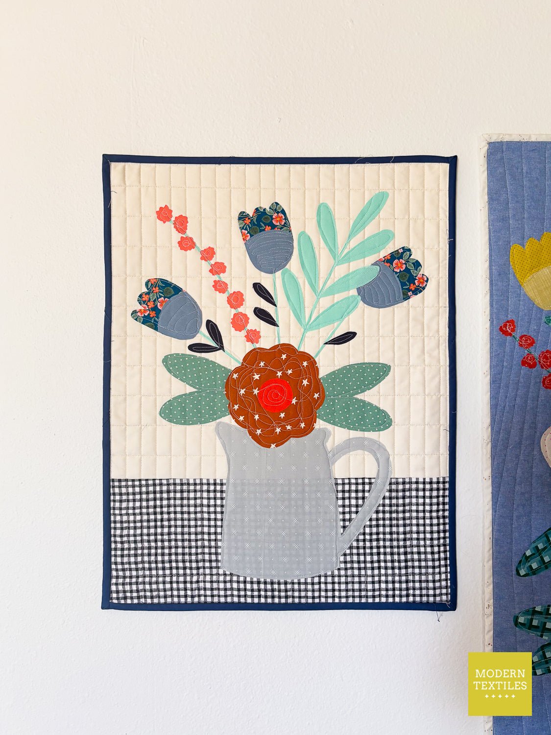 Floral appliqué mini quilt featuring bouquet in gray pitcher