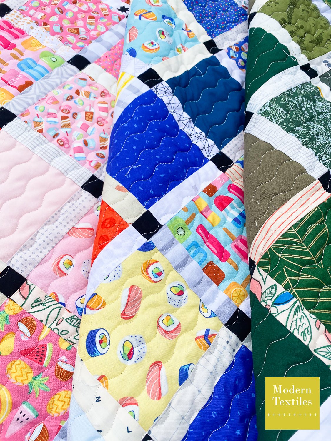 Scrappy Rainbow patchwork quilt using domestic waves for the quilting. Quilt is folded over on itself for dimension.