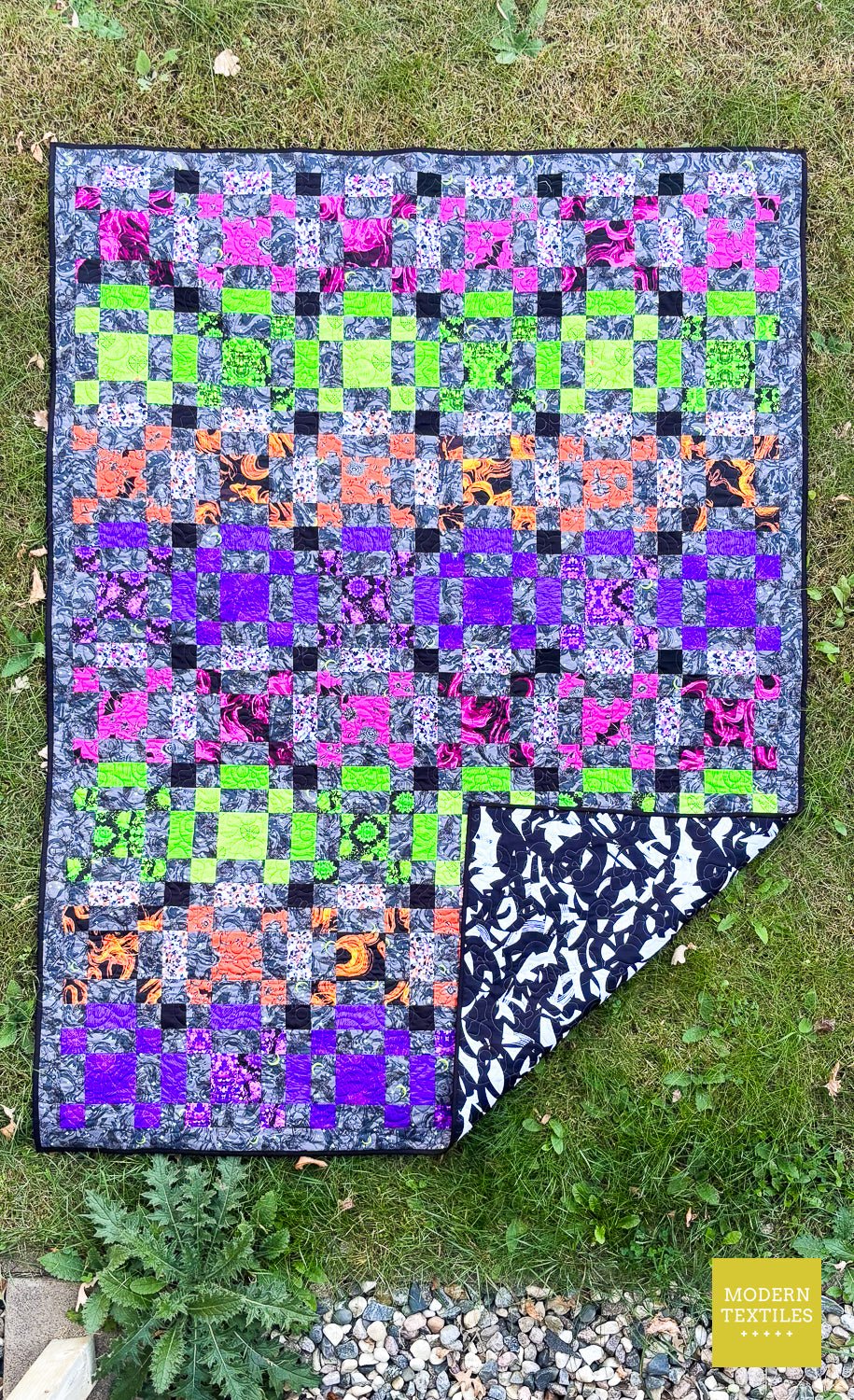 Finished modern quilt made with Phantasm fabrics and quilted using the Rose and Skulls pantograph.