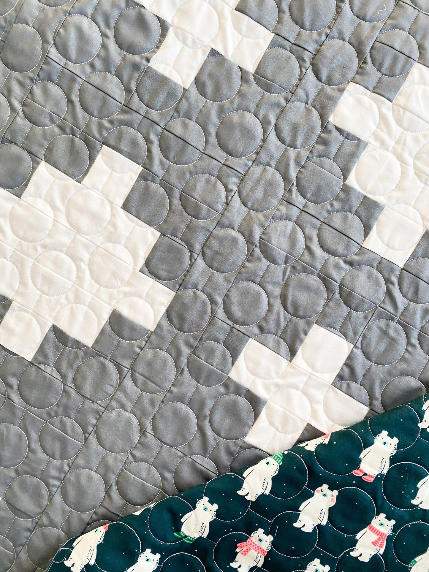 Close-up of edge-to-edge longarm quilting on the Not So XOXO quilt showing circle pantograph texture.