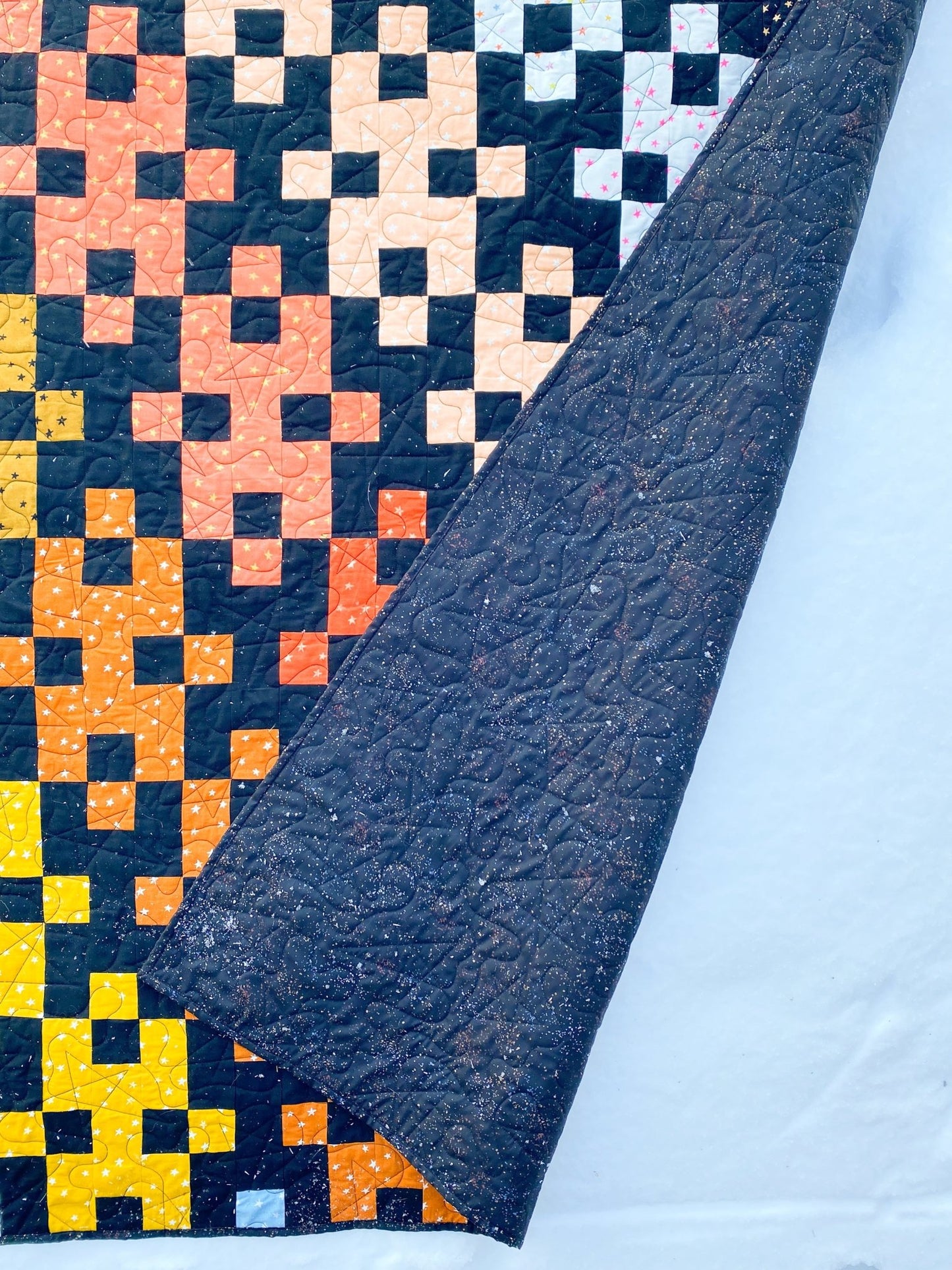 Detail view of Diamond Plate quilt backing and edge binding with modern quilting stitches.