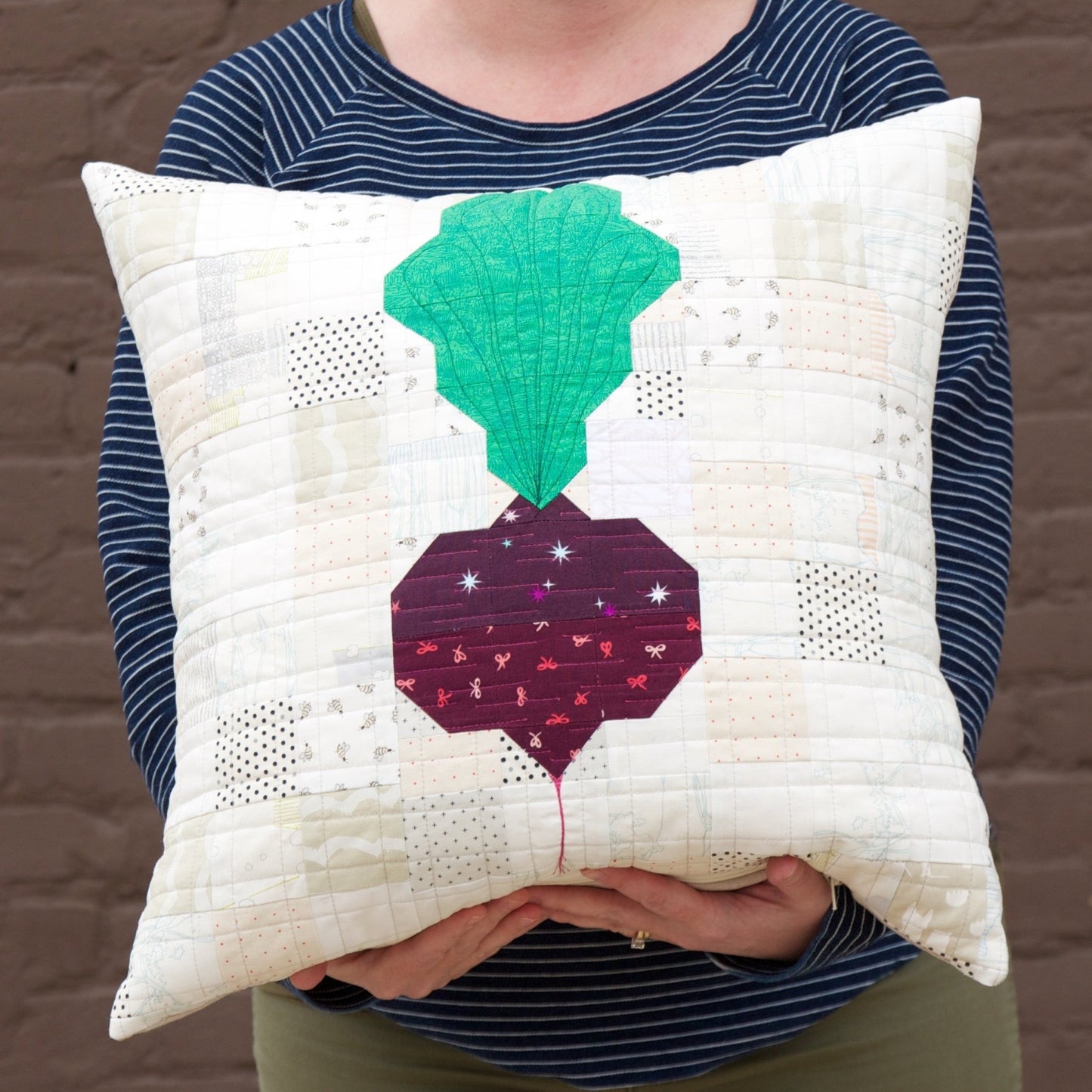Decorative quilted pillow featuring a beet motif from the Veggie quilt pattern.