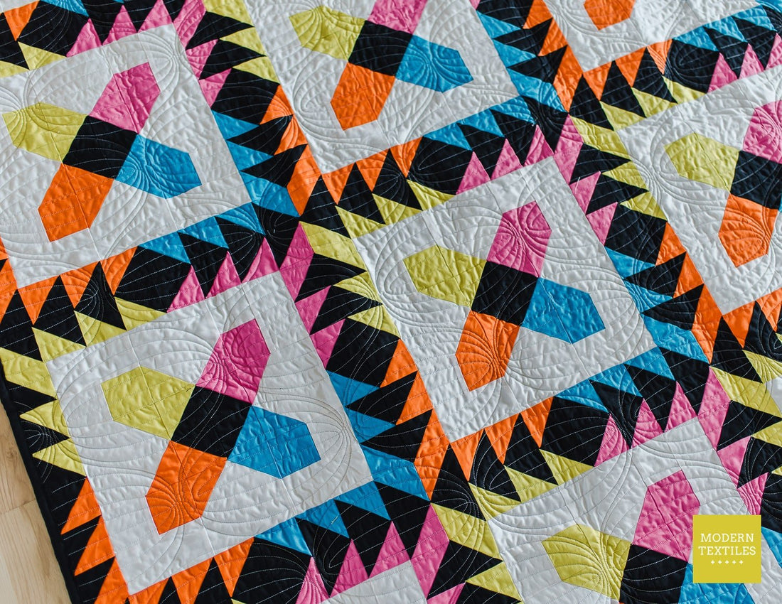 Quilt shown on the diagonal highlighting the texture of the quilting and the black accent fabric.