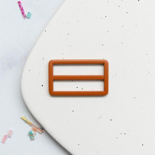 Carmel rectangular tri-glide buckle on a speckled white plate