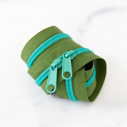 Rolled up mossy green zipper with two turquoise zipper pulls on a white background.