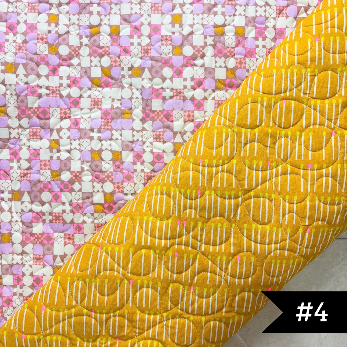 A quilted fabric panel shown diagonally, featuring a bright yellow lining fabric with white stitched cakewalk quilt panto and a pink, white, and yellow patchwork printed exterior. #4 in white on a black tag on lower right hand corner.
