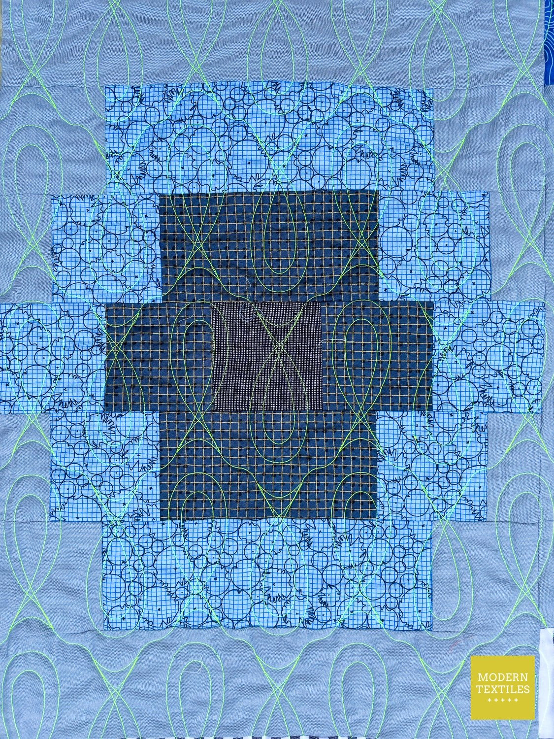 Quilt block with geometric pattern on a blue background