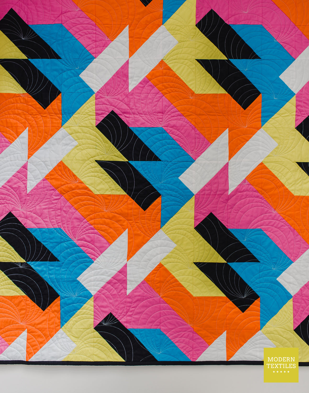 Close-up view of the Sheared modern quilt pattern featuring repeating geometric shapes in vibrant modern fabrics.