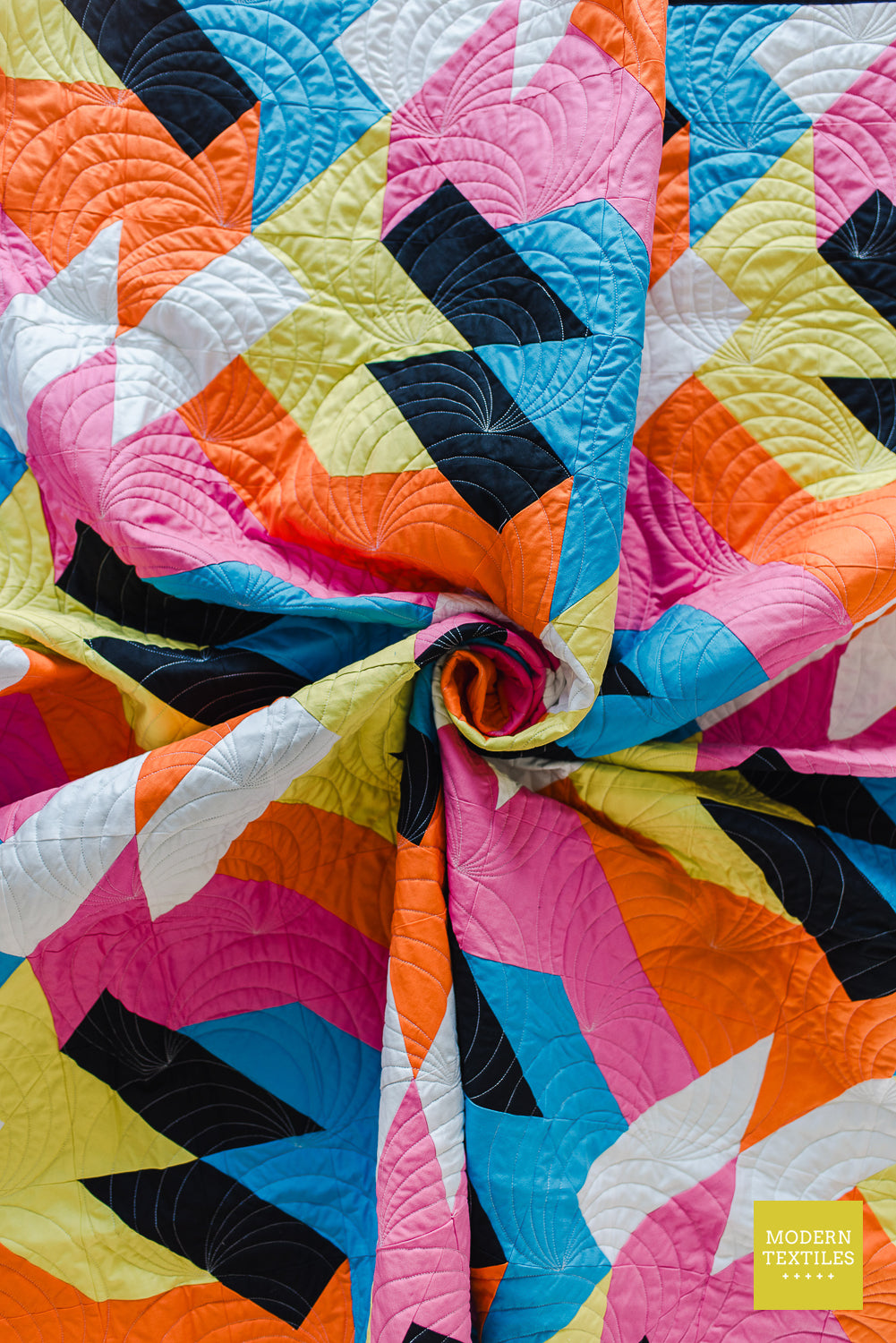 Fabric swirl detail of the Sheared modern quilt highlighting colorful geometric patchwork in bright modern fabrics.