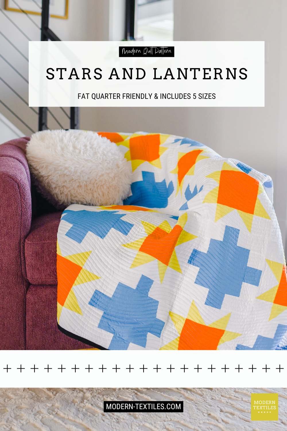 Close-up of blue patchwork quilt with sawtooth stars in orange and yellow-green with white background fabric and black binding fabric draped across maroon colored chair with white fluffy pillow on top of quilt. Text overlay reads: Modern Quilt Pattern, Stars and Lanterns, Fat Quarter Friendly & includes 5 sizes, modern-textiles.com.