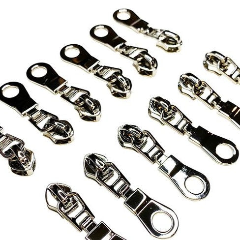 Multiple nickel metal zipper pullers on a white background
