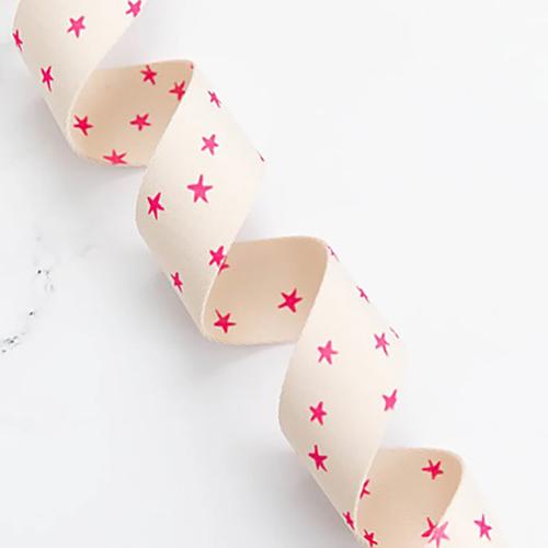Off white webbing with hot pink stars on a white background.