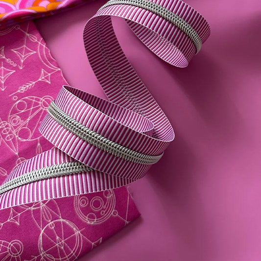 Purple and white striped zipper tape with on a purple background with purple fabric.