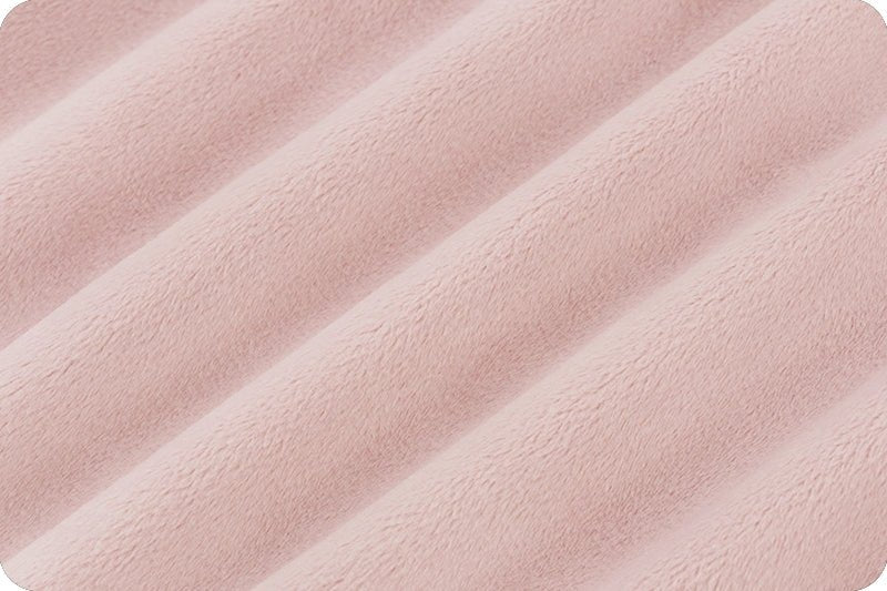 Light pink minky fabric folded onto itself multiple times on the diagonal to show dimension of fabric.